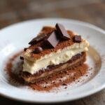 Finished chocolate coffee charlotte tiramisu decorated with cocoa and chocolate shavings.