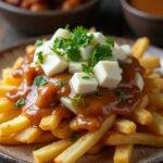 Poutine traditionnelle au fromage en grains servie dans une assiette rustique, mettant en valeur des frites croustillantes et du fromage fondant.