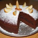 Gâteau au chocolat poire amande gourmand, élégant sur une table en bois, avec une touche de sucre en poudre et des amandes, un dessert maison irrésistible.