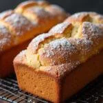 Pain à la Cannelle parfaitement cuit sur une grille, la croûte dorée et saupoudrée de sucre glace.