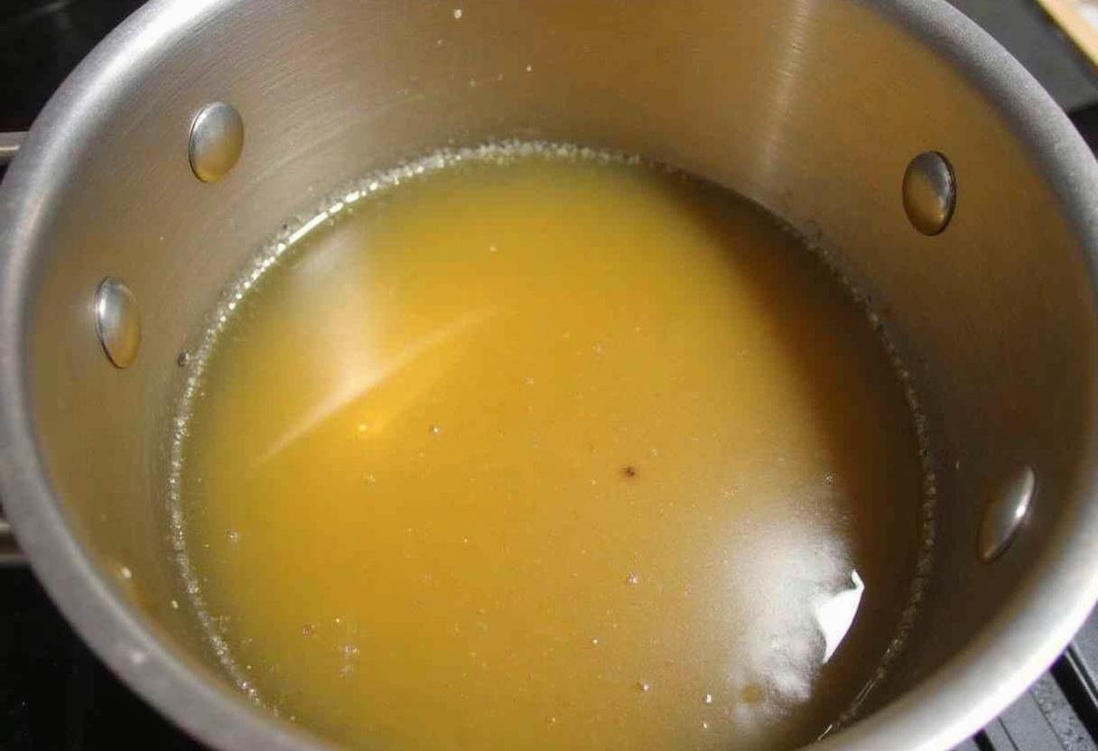 Mélange du sirop de gingembre sur le feu doux, avec le sucre complètement dissous dans le liquide.