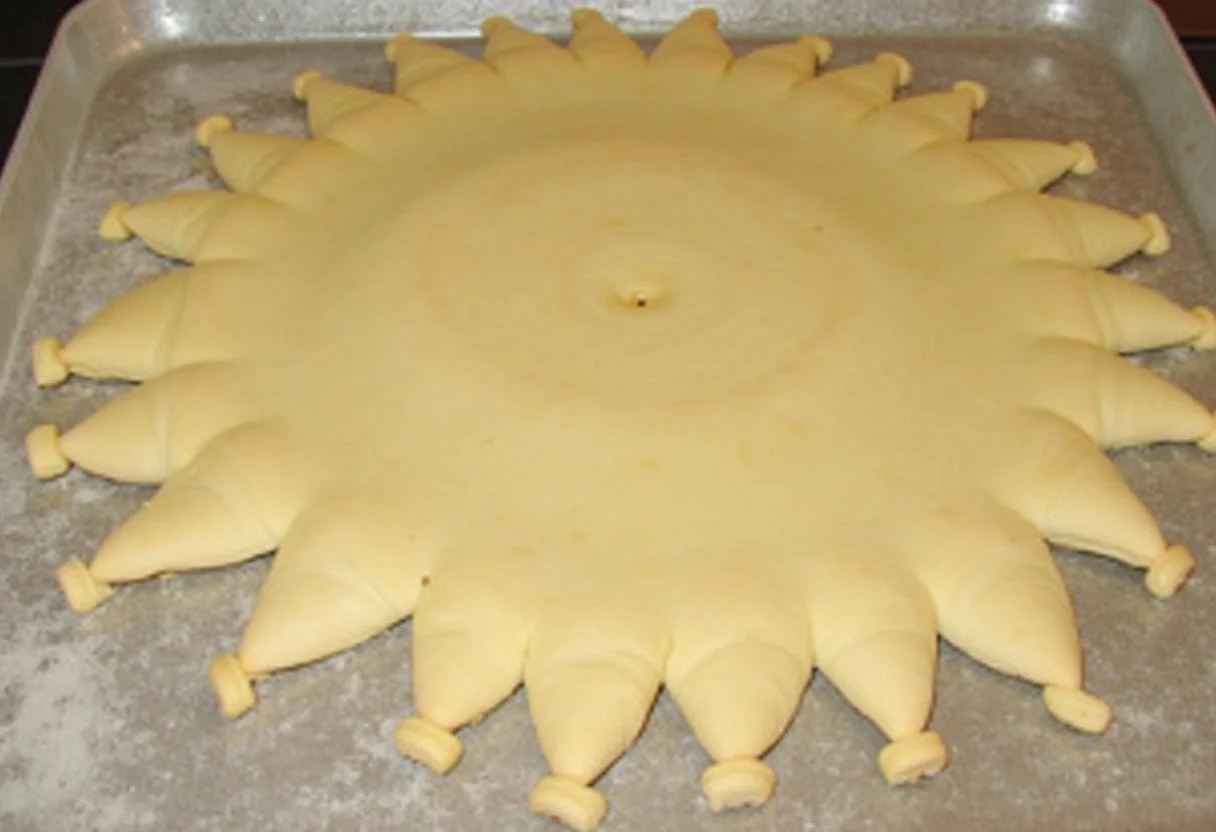 Découpe des fentes décoratives sur la croûte de la tarte soleil jambon fromage pour une belle présentation.