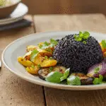 Présentation finale du riz noir cuit avec des légumes grillés, style rustique.