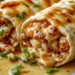 A close-up of a freshly made cheesy garlic chicken wrap cut in half, revealing juicy grilled chicken, melted cheese, crispy lettuce, and garlic sauce inside a golden-brown tortilla, styled with a few herbs for garnish.