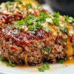 A golden-brown air fryer meatloaf sliced open to reveal a moist, tender interior with a slightly crispy crust on top, served on a rustic plate with fresh herbs and a side of roasted vegetables.