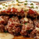 A perfectly sliced one pound meatloaf on a rustic wooden cutting board, topped with a glossy tomato glaze. The slices reveal a moist, tender interior with herbs and spices visible throughout, accompanied by a side of mashed potatoes and fresh green beans, all styled for a cozy, inviting dinner setting.